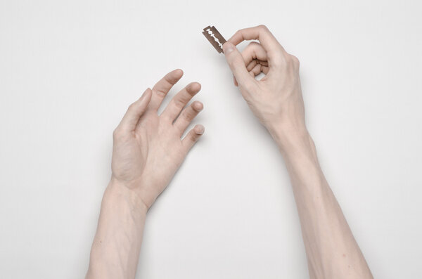 Суицид и тема Хэллоуина: человеческая рука, держащая пламя к самоубийству, изолированная на белом фоне в студии сверху
