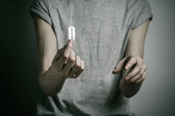Depressionen und Selbstmord Thema: Mann mit Rasiermesser zum Selbstmord vor grauem Hintergrund im Studio — Stockfoto