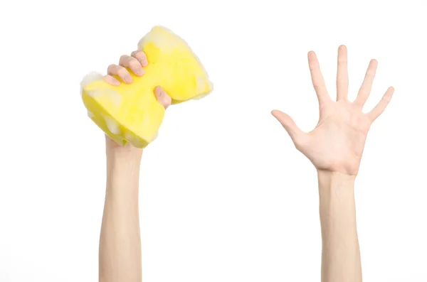 Pulizia della casa e igiene argomento: mano che tiene una spugna gialla bagnata con schiuma isolata su uno sfondo bianco in studio — Foto Stock