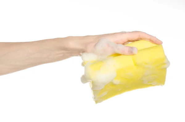 Cleaning the house and sanitation topic: Hand holding a yellow sponge wet with foam isolated on a white background in studio — Stock Photo, Image