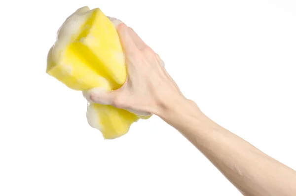 Cleaning the house and sanitation topic: Hand holding a yellow sponge wet with foam isolated on a white background in studio — Stock Photo, Image