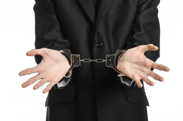 Corruption and bribery theme: businessman in a black suit with handcuffs on his hands on a white background in studio isolated — Stock Photo, Image