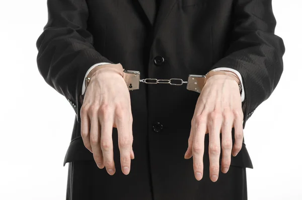 Corruption and bribery theme: businessman in a black suit with handcuffs on his hands on a white background in studio isolated — Stock Photo, Image