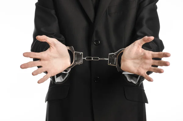 腐敗と汚職のテーマ: 分離されたスタジオの白い背景の上の彼の手に手錠で黒のスーツのビジネスマン — ストック写真