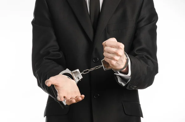 Corruption and bribery theme: businessman in a black suit with handcuffs on his hands on a white background in studio isolated — Stock Photo, Image