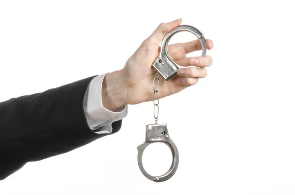 Corruption and bribery theme: businessman in a black suit with handcuffs on his hands on a white background in studio isolated — Stock Photo, Image