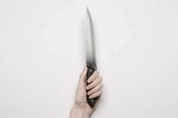 Murder and Halloween theme: A man's hand reaching for a knife, a human hand holding a knife isolated on a gray background in studio from above — Stock Photo, Image