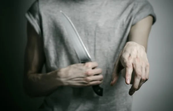 Cinayet ve Halloween Tema: gri bir arka plan üzerinde elinde bir bıçakla bir adam — Stok fotoğraf