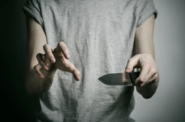 Murder and Halloween theme: a man holding a knife on a gray background — Stock Photo, Image