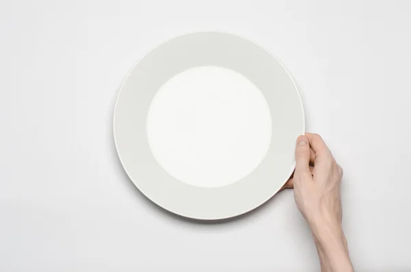 Restaurante e comida tema: o gesto de mão humana mostrar em uma placa branca vazia em um fundo branco em estúdio isolado vista superior — Fotografia de Stock