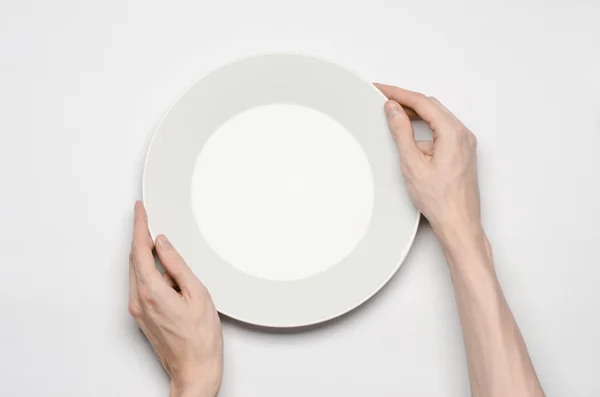 Restaurante e comida tema: o gesto de mão humana mostrar em uma placa branca vazia em um fundo branco em estúdio isolado vista superior — Fotografia de Stock
