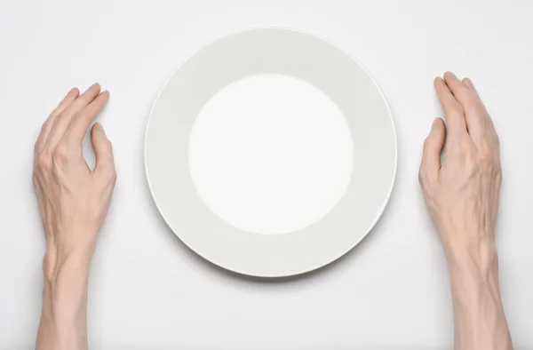 Restaurante e comida tema: o gesto de mão humana mostrar em uma placa branca vazia em um fundo branco em estúdio isolado vista superior — Fotografia de Stock