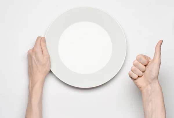 Restaurante e comida tema: o gesto de mão humana mostrar em uma placa branca vazia em um fundo branco em estúdio isolado vista superior — Fotografia de Stock