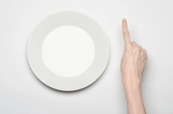 Restoran ve gıda Tema: insan eli göstermek jest beyaz bir arka plan üzerinde boş bir beyaz tabakta izole studio Üstten Görünüm — Stok fotoğraf