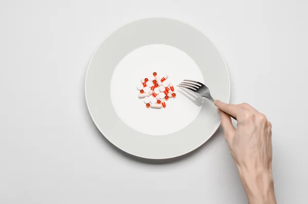 Farmaci e nutrizione impropria argomento: mano umana tenere un piatto con pillole isolate su sfondo bianco vista dall'alto — Foto Stock