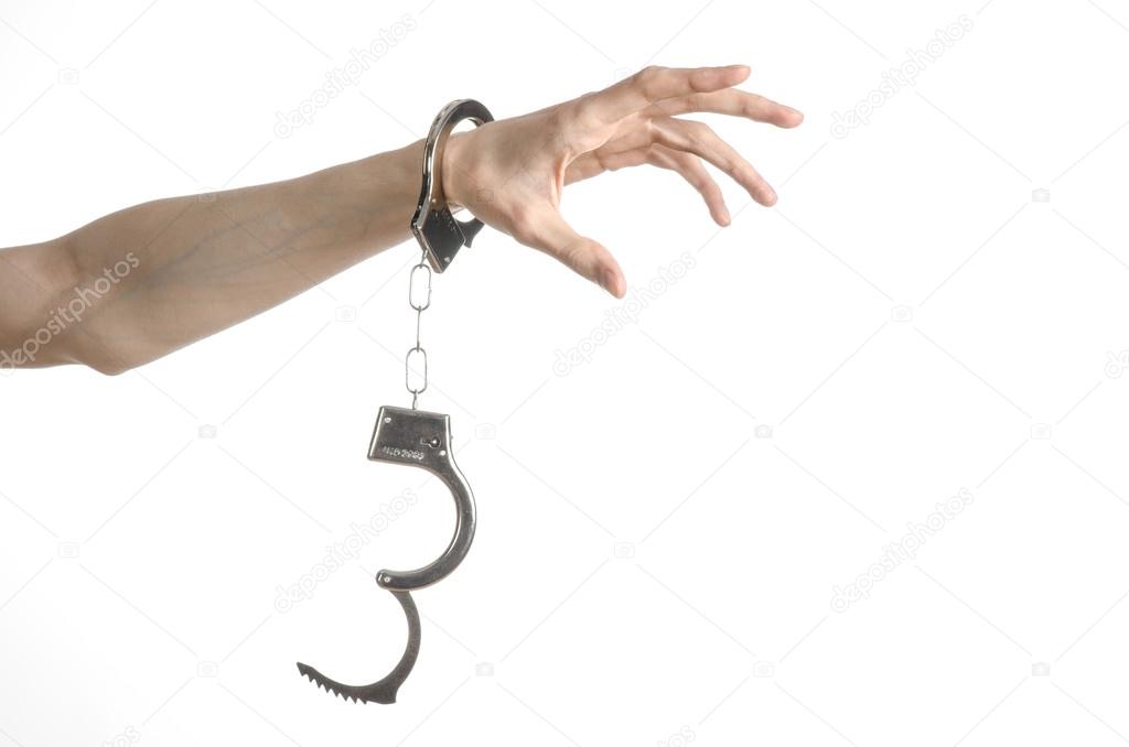 Prison and convicted topic: man hands with handcuffs isolated on white background in studio, put handcuffs on killer