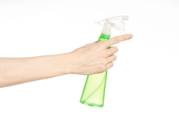 Limpieza de la casa y tema más limpio: la mano del hombre sosteniendo una botella de spray verde para la limpieza aislada sobre un fondo blanco — Foto de Stock