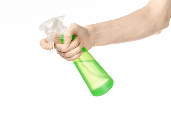 Cleaning the house and cleaner theme: man 's hand holding a green spray bottle for cleaning isolated on a white background — стоковое фото