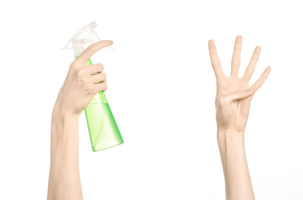 Cleaning the house and cleaner theme: man 's hand holding a green spray bottle for cleaning isolated on a white background — стоковое фото