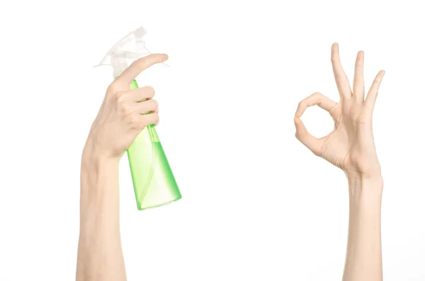 Прибирання будинку і чистіша тема: рука людини тримає зелену пляшку розпилювача для прибирання ізольовано на білому тлі — стокове фото