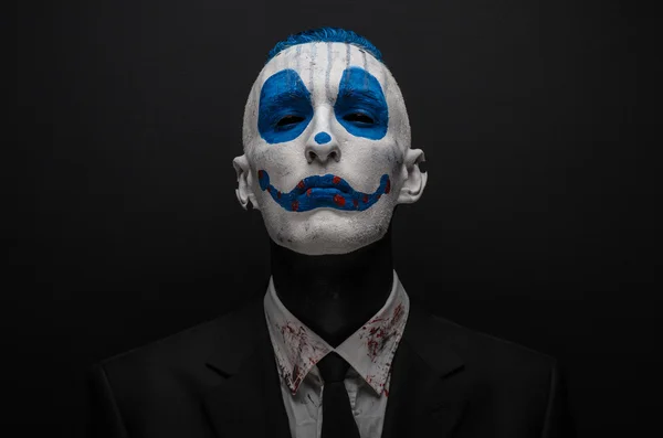 Terrible clown et thème Halloween : clown bleu fou en costume noir isolé sur un fond sombre en studio — Photo