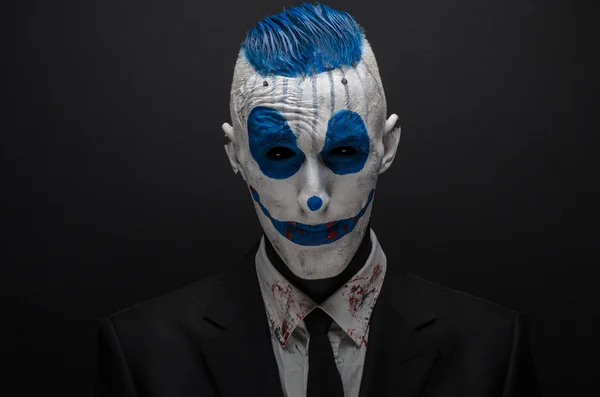 Terrible clown and Halloween theme: Crazy blue clown in black suit isolated on a dark background in the studio — 스톡 사진