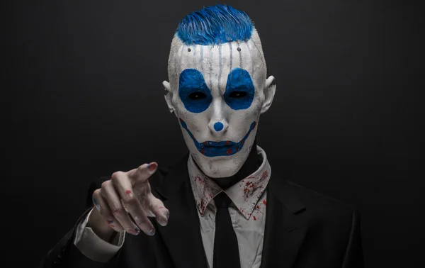 Terrible clown and Halloween theme: Crazy blue clown in black suit isolated on a dark background in the studio — Stockfoto