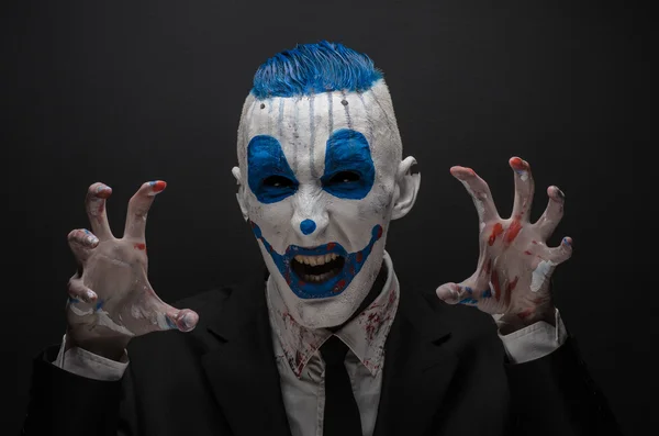 Terrible clown and Halloween theme: Crazy blue clown in black suit isolated on a dark background in the studio — 图库照片