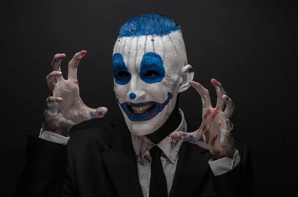 Terrible clown and Halloween theme: Crazy blue clown in black suit isolated on a dark background in the studio — Stockfoto