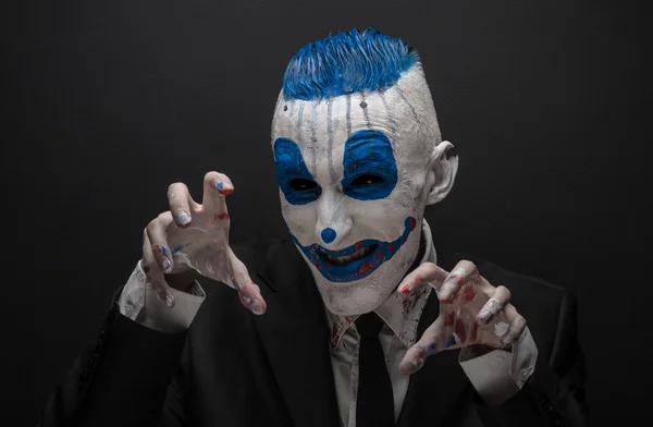 Terrible clown and Halloween theme: Crazy blue clown in black suit isolated on a dark background in the studio — Stock Fotó