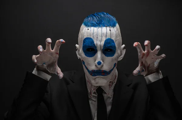 Terrible clown and Halloween theme: Crazy blue clown in black suit isolated on a dark background in the studio — Stockfoto
