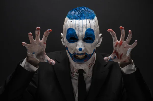 Terrible clown and Halloween theme: Crazy blue clown in black suit isolated on a dark background in the studio — Stockfoto