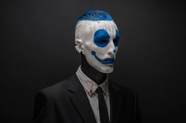 Ужасный клоун и Хэллоуин тема: Crazy синий клоун в черном костюме изолированы на темном фоне в студии — стоковое фото