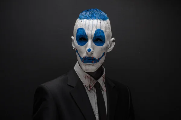 Terrible clown and Halloween theme: Crazy blue clown in black suit isolated on a dark background in the studio — 图库照片