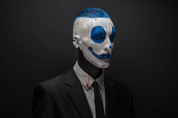 Terrible clown and Halloween theme: Crazy blue clown in black suit isolated on a dark background in the studio — Φωτογραφία Αρχείου