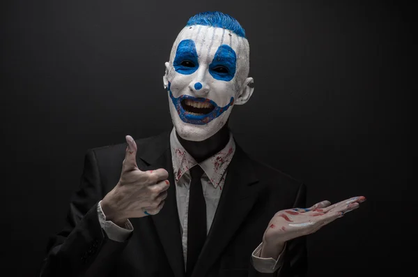 Жахливий клоун і тема Хеллоуїна: Божевільний синій клоун в чорному костюмі ізольований на темному тлі в студії — стокове фото