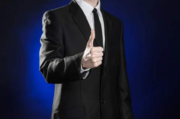 Business and the presentation of the theme: man in a black suit showing hand gestures on a dark blue background in studio isolated — 스톡 사진