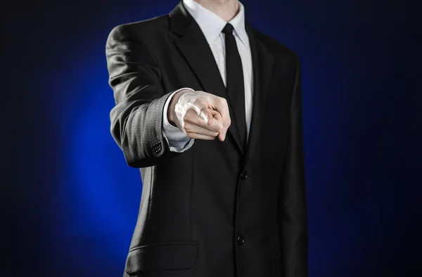 Negócios e a apresentação do tema: homem de terno preto mostrando gestos de mão em um fundo azul escuro em estúdio isolado — Fotografia de Stock