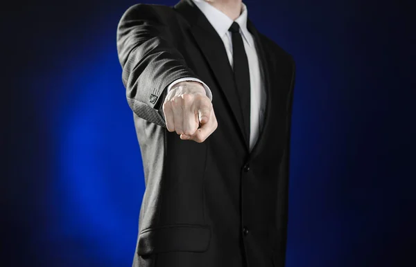 Business and the presentation of the theme: man in a black suit showing hand gestures on a dark blue background in studio isolated — Stok fotoğraf