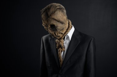 Fear and Halloween theme: a brutal killer in a mask on a dark background in the studio