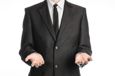 Businessman and gesture topic: a man in a black suit and tie holding two hands in front isolated on white background in studio