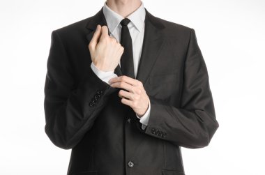 Businessman and gesture topic: a man in a black suit with a tie coat straightens his arms isolated on a white background in studio