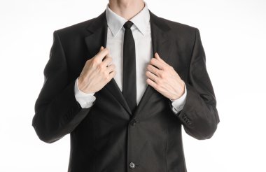 Businessman and gesture topic: a man in a black suit with a tie coat straightens his arms isolated on a white background in studio