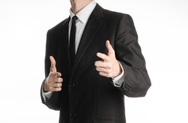 Businessman and gesture topic: a man in a black suit with a tie showing a sign on your hands on an isolated white background in studio
