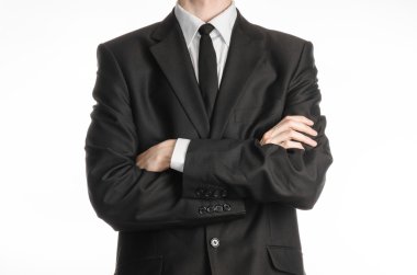 Businessman and gesture topic: a man in a black suit with a tie folded his hands in front of him isolated on a white background in studio
