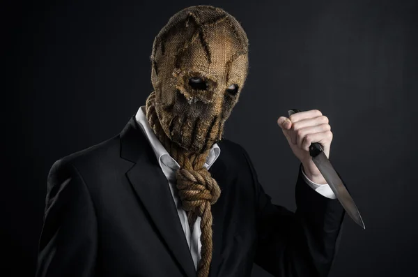 Fear and Halloween theme: a brutal killer in a mask holding a knife on a dark background in the studio — 스톡 사진