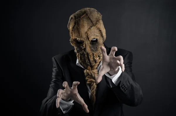 Fear and Halloween theme: a brutal killer in a mask on a dark background in the studio — Stok fotoğraf