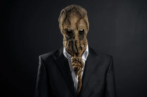 Medo e tema de Halloween: um assassino brutal em uma máscara em um fundo escuro no estúdio — Fotografia de Stock