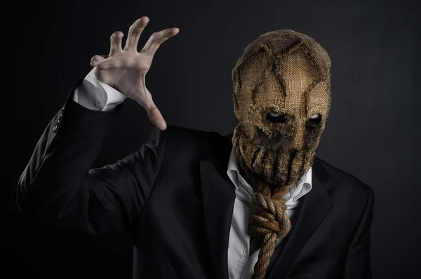 Tema Miedo y Halloween: un asesino brutal en una máscara sobre un fondo oscuro en el estudio —  Fotos de Stock