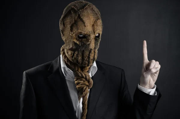 Fear and Halloween theme: a brutal killer in a mask on a dark background in the studio — Stockfoto